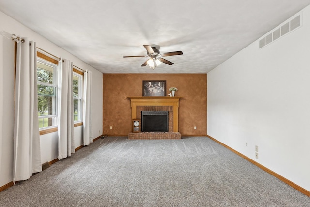 307 Shelden Dr, Winnebago, IL 61088 - unfurnished living room featuring ceiling fan, baseboards, a brick fireplace, and carpet floors