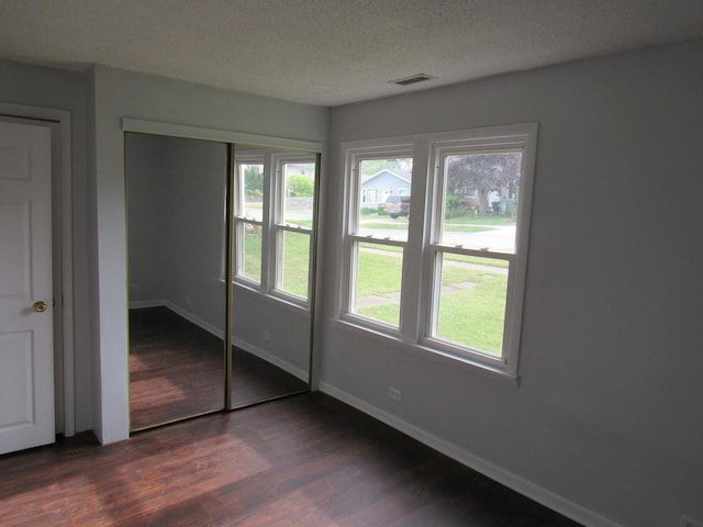 1503 Cherokee Dr, Round Lake Beach, IL 60073 - unfurnished bedroom with dark wood-style flooring, baseboards, a closet, and a textured ceiling