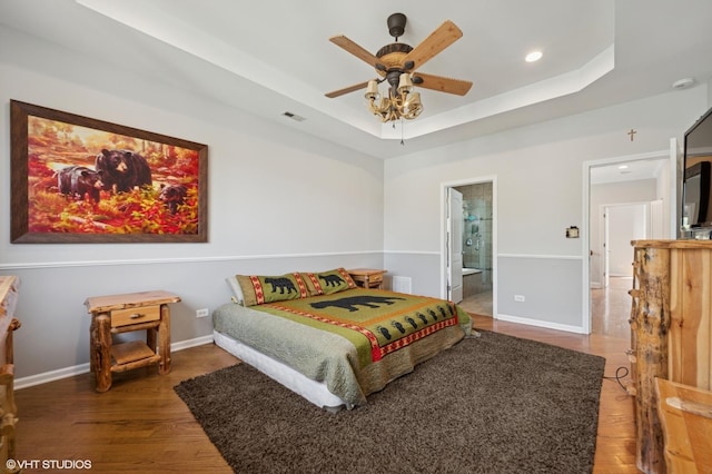4218 N California Ave, Chicago, IL 60618 - bedroom with a tray ceiling, wood finished floors, recessed lighting, connected bathroom, and baseboards
