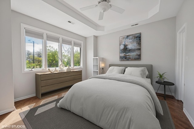 4218 N California Ave, Chicago, IL 60618 - bedroom featuring baseboards, a tray ceiling, wood finished floors, and a ceiling fan