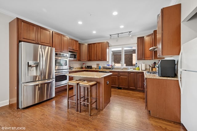 4218 N California Ave, Chicago, IL 60618 - kitchen featuring stainless steel appliances, crown molding, a kitchen bar, a kitchen island, and recessed lighting