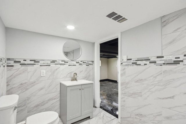 8428 S Rhodes Ave, Chicago, IL 60619 - bathroom featuring toilet, marble finish floors, vanity, and tile walls
