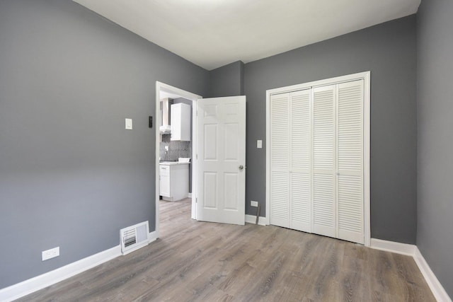 8428 S Rhodes Ave, Chicago, IL 60619 - unfurnished bedroom featuring wood finished floors, baseboards, and a closet
