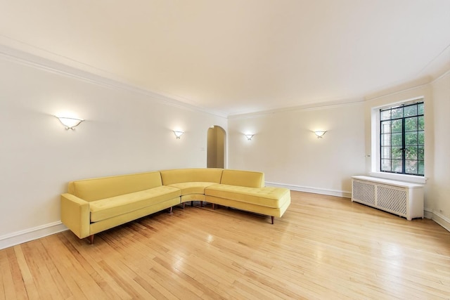 7350 N Ridge Blvd Unit 21B, Chicago, IL 60645 - living area featuring radiator heating unit, ornamental molding, light wood finished floors, arched walkways, and baseboards