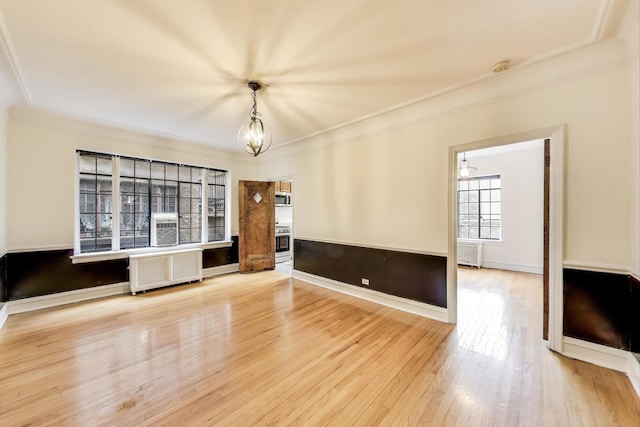 7350 N Ridge Blvd Unit 21B, Chicago, IL 60645 - unfurnished living room featuring radiator, a chandelier, crown molding, and wood finished floors