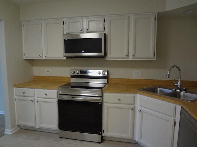1108 Castilian Ct Unit 121, Glenview, IL 60025 - kitchen with stainless steel appliances, a sink, white cabinetry, and light countertops