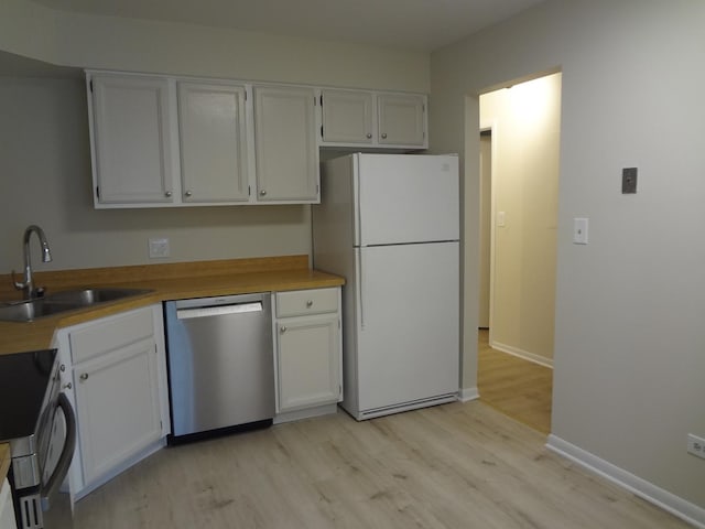 1108 Castilian Ct Unit 121, Glenview, IL 60025 - kitchen with appliances with stainless steel finishes, a sink, light wood-type flooring, and white cabinetry