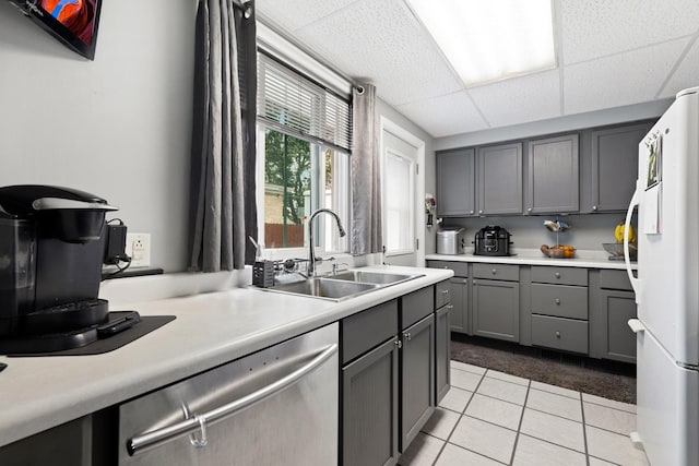 14453 Kolin Ave, Midlothian, IL 60445 - kitchen with gray cabinetry, a sink, stainless steel dishwasher, freestanding refrigerator, and light tile patterned floors