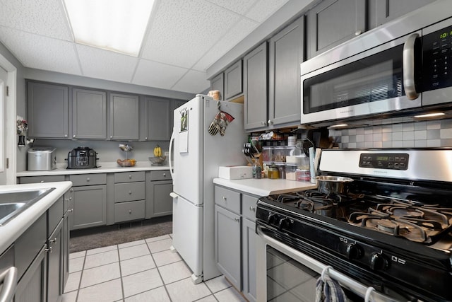 14453 Kolin Ave, Midlothian, IL 60445 - kitchen featuring stainless steel appliances, gray cabinetry, a drop ceiling, light countertops, and light tile patterned floors