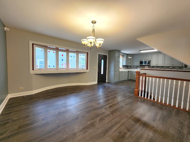 5115 E Ln, Mchenry, IL 60050 - unfurnished living room with a chandelier, dark wood-style flooring, and baseboards