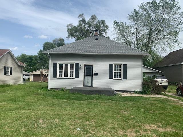122 Portland Ave, Oglesby, IL 61348 - back of property featuring a yard, roof with shingles, and a chimney