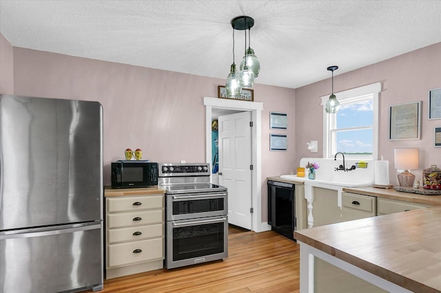 55 N 2600e Rd, Rankin, IL 60960 - kitchen featuring black appliances, light wood-type flooring, pendant lighting, light countertops, and a textured ceiling
