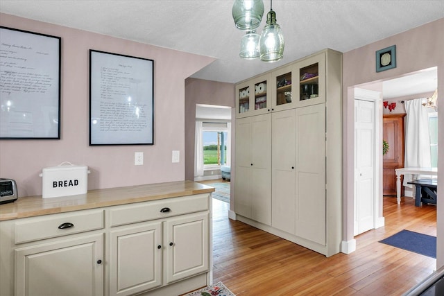55 N 2600e Rd, Rankin, IL 60960 - kitchen featuring a chandelier, light wood finished floors, glass insert cabinets, light countertops, and a textured ceiling