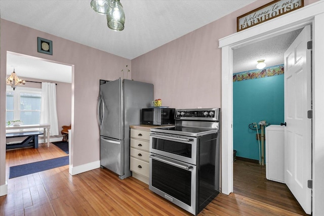 55 N 2600e Rd, Rankin, IL 60960 - kitchen with stainless steel appliances, light wood-type flooring, a textured ceiling, a chandelier, and baseboards
