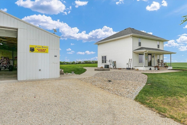55 N 2600e Rd, Rankin, IL 60960 - view of side of home with a porch, a lawn, and a shingled roof