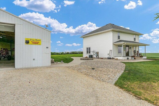 55 N 2600e Rd, Rankin, IL 60960 - view of home's exterior with covered porch, a yard, central AC, and roof with shingles
