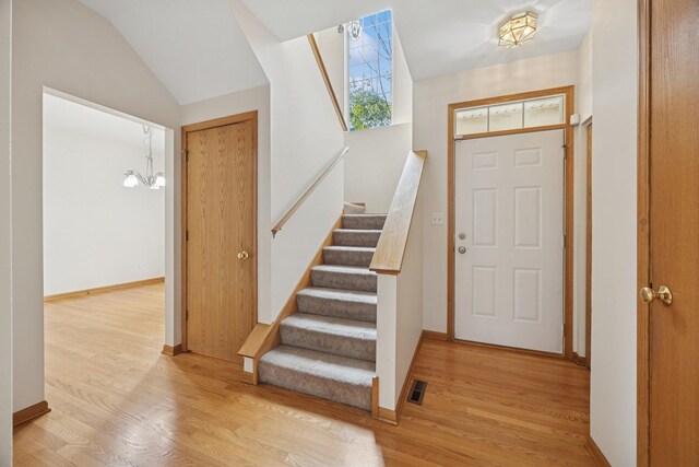 18582 W Point Dr, Tinley Park, IL 60477 - entrance foyer featuring light wood-type flooring, stairs, lofted ceiling, baseboards, and a chandelier