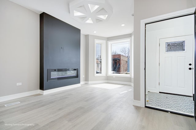 3926 W Arthington St, Chicago, IL 60624 - foyer featuring light wood-type flooring, baseboards, recessed lighting, and a glass covered fireplace