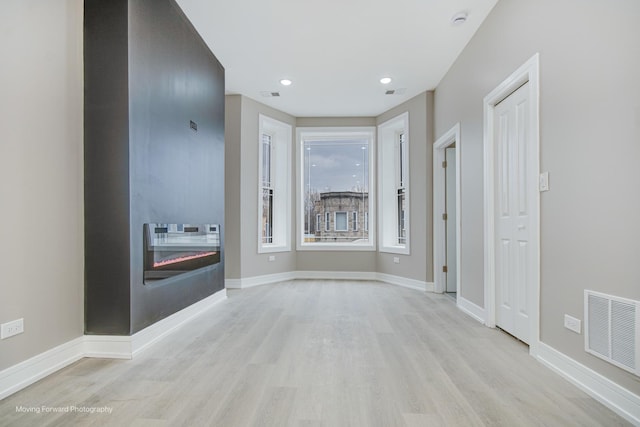 3926 W Arthington St, Chicago, IL 60624 - empty room with a glass covered fireplace, wood finished floors, a smoke detector, recessed lighting, and baseboards