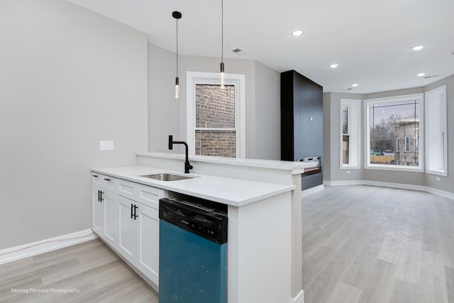 3926 W Arthington St, Chicago, IL 60624 - kitchen featuring dishwasher, a sink, light wood finished floors, a peninsula, and decorative light fixtures