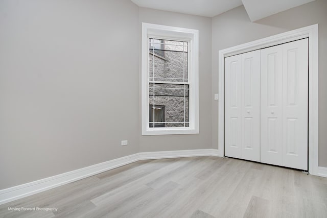 3926 W Arthington St, Chicago, IL 60624 - unfurnished bedroom with light wood finished floors, baseboards, and a closet