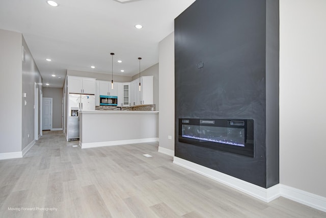 3926 W Arthington St, Chicago, IL 60624 - unfurnished living room featuring a large fireplace, light wood finished floors, recessed lighting, and baseboards