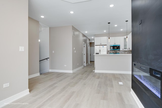 3926 W Arthington St, Chicago, IL 60624 - unfurnished living room featuring light wood-type flooring, baseboards, and recessed lighting