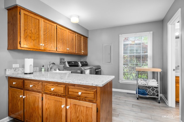 1900 Millburne Rd, Lake Forest, IL 60045 - kitchen featuring washer and clothes dryer, brown cabinetry, electric panel, baseboards, and light wood finished floors