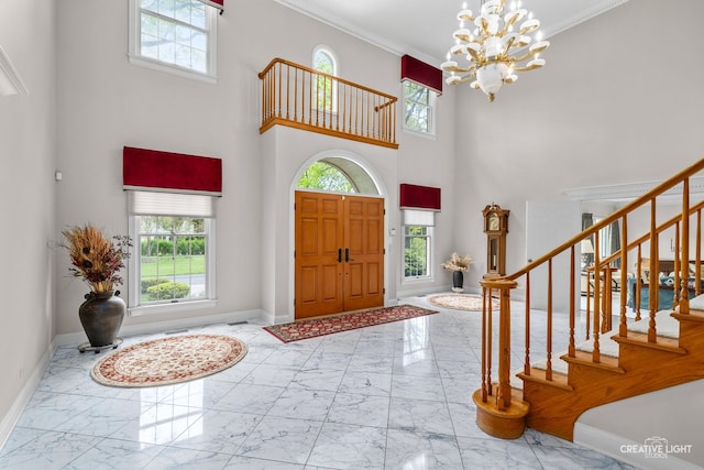 1900 Millburne Rd, Lake Forest, IL 60045 - entryway featuring marble tiled flooring, plenty of natural light, a high ceiling, baseboards, and crown molding