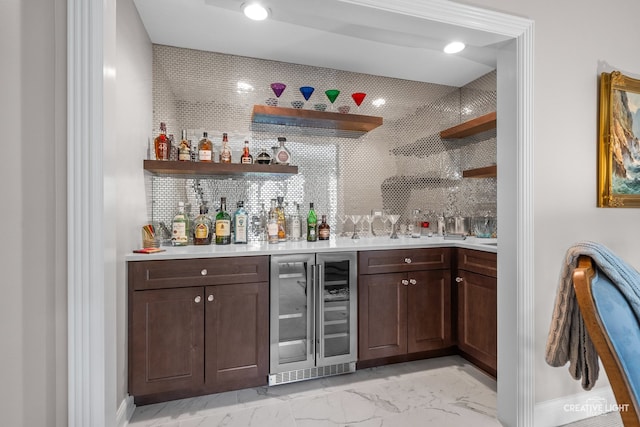 1900 Millburne Rd, Lake Forest, IL 60045 - indoor bar featuring wine cooler, baseboards, light marble finish flooring, recessed lighting, and decorative backsplash