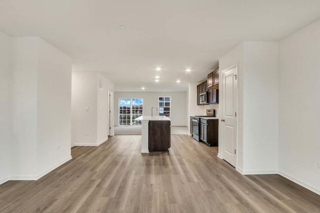 358 Bridgeview Ct, Saint Charles, IL 60174 - kitchen with appliances with stainless steel finishes, an island with sink, light countertops, dark brown cabinetry, and light wood finished floors