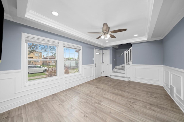 9632 S Yale Ave, Chicago, IL 60628 - spare room featuring a raised ceiling, crown molding, a wainscoted wall, stairway, and ceiling fan