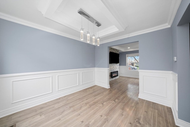 9632 S Yale Ave, Chicago, IL 60628 - spare room featuring ornamental molding, a raised ceiling, a glass covered fireplace, light wood finished floors, and a wainscoted wall