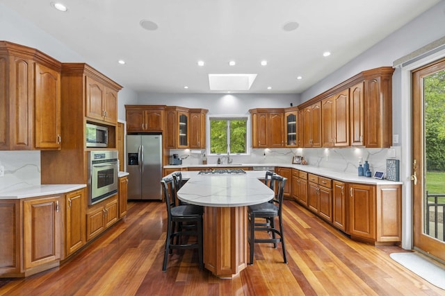 8600 Beall St, Dyer, IN 46311 - kitchen with stainless steel appliances, a skylight, a kitchen breakfast bar, wood finished floors, and a kitchen island