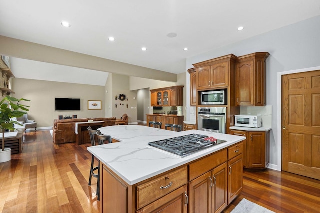 8600 Beall St, Dyer, IN 46311 - kitchen featuring stainless steel appliances, dark wood-type flooring, a center island, brown cabinets, and a kitchen bar