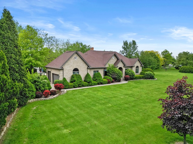 8600 Beall St, Dyer, IN 46311 - french country home featuring a front yard, a garage, a chimney, and a shingled roof