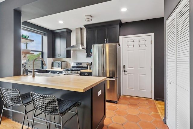 5730 N Hermitage Ave Unit 2, Chicago, IL 60660 - kitchen with wall chimney exhaust hood, stainless steel appliances, butcher block counters, a breakfast bar, and a sink