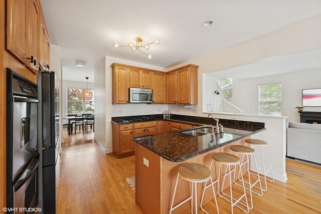 2363 Trailside Ln, Wauconda, IL 60084 - kitchen featuring stainless steel appliances, a sink, light wood-style floors, a peninsula, and plenty of natural light