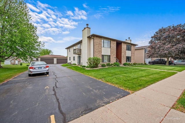 11405 Douglas Ave Unit D, Huntley, IL 60142 - view of front facade with a chimney, a front lawn, and a detached garage