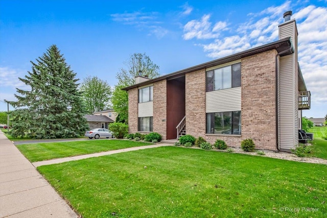 11405 Douglas Ave Unit D, Huntley, IL 60142 - view of front facade with a chimney, a front yard, and brick siding