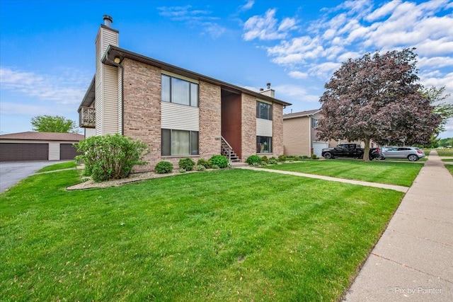 11405 Douglas Ave Unit D, Huntley, IL 60142 - view of front facade with a chimney, a front yard, brick siding, and a detached garage
