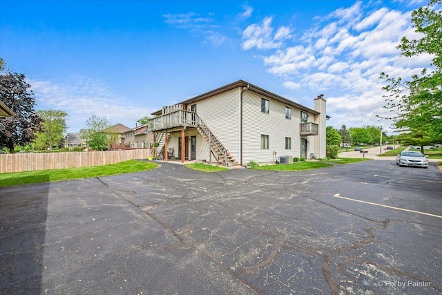 11405 Douglas Ave Unit D, Huntley, IL 60142 - back of property with stairs, central air condition unit, a chimney, a wooden deck, and uncovered parking