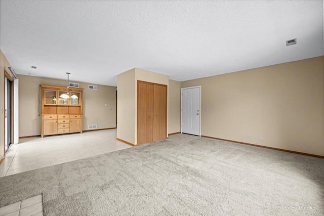 11405 Douglas Ave Unit D, Huntley, IL 60142 - unfurnished living room featuring light colored carpet, baseboards, and a textured ceiling