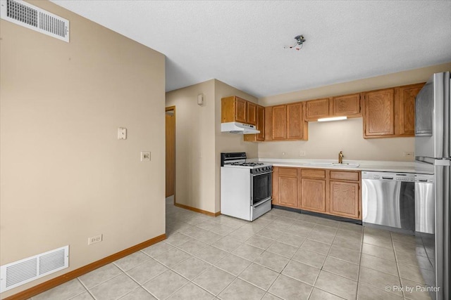 11405 Douglas Ave Unit D, Huntley, IL 60142 - kitchen with appliances with stainless steel finishes, under cabinet range hood, light countertops, baseboards, and light tile patterned floors