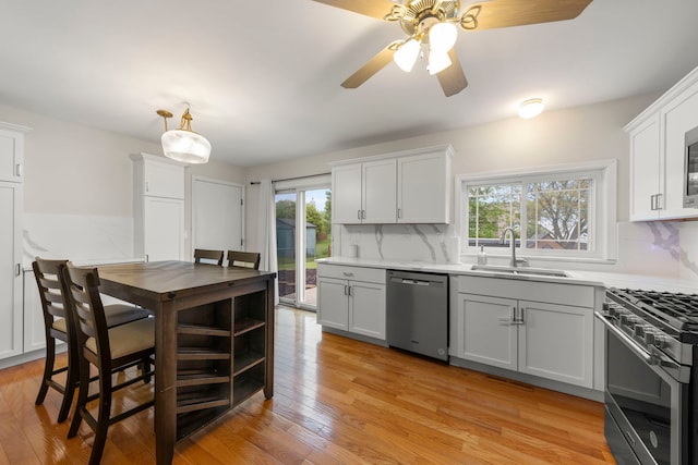 1191 Narragansett Dr, Carol Stream, IL 60188 - kitchen with appliances with stainless steel finishes, a sink, backsplash, light countertops, and light wood-type flooring