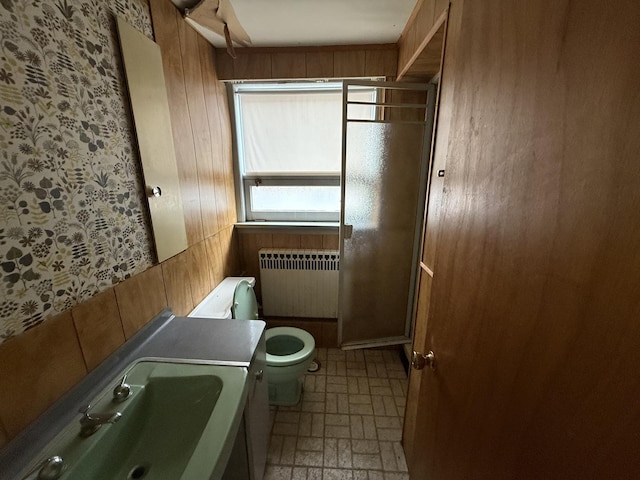 1850 Garland Ave, Highland Park, IL 60035 - bathroom featuring radiator heating unit, toilet, wooden walls, vanity, and brick patterned floors
