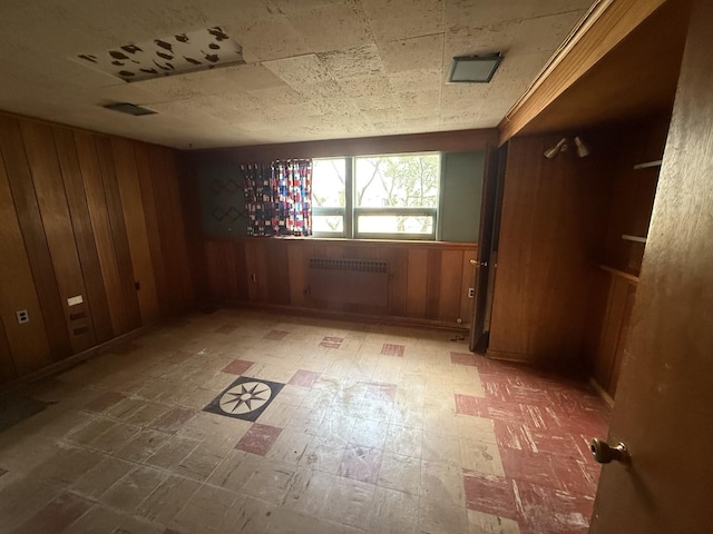 1850 Garland Ave, Highland Park, IL 60035 - unfurnished room with radiator heating unit, wooden walls, and tile patterned floors