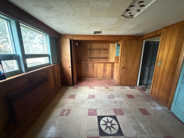 1850 Garland Ave, Highland Park, IL 60035 - unfurnished bedroom featuring radiator heating unit, wooden walls, and light floors