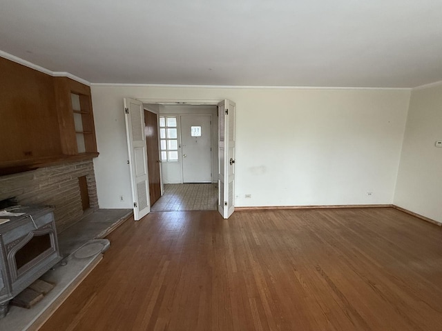 1850 Garland Ave, Highland Park, IL 60035 - unfurnished living room featuring a wood stove, baseboards, wood finished floors, and crown molding