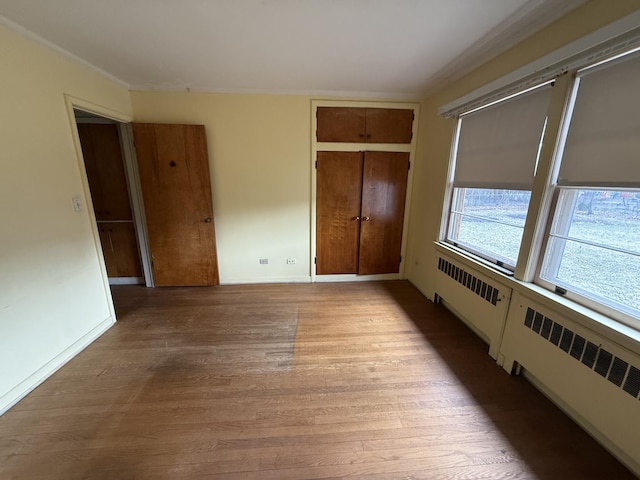 1850 Garland Ave, Highland Park, IL 60035 - unfurnished bedroom with light wood-style floors, radiator, and a closet